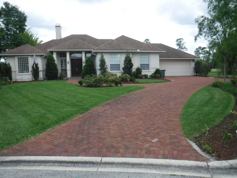 dark green grass after mowing with stripes in Eagle Harbor in Fleming Island, FL with paver driveway