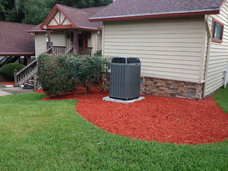 red mulch in flowerbed and around ac unit in Fleming Island, FL