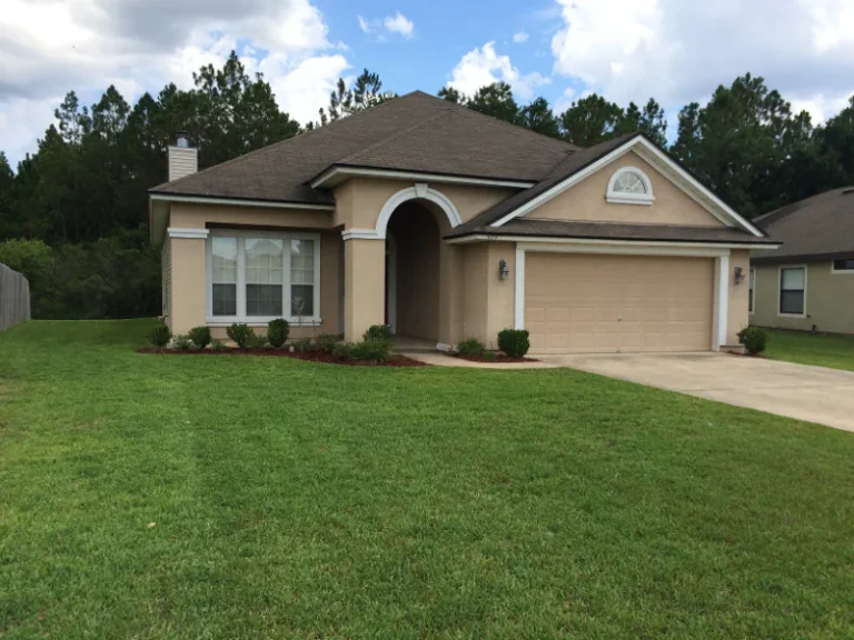 Nicely mowed small lawn and beige colored home in Oakleaf area in Orange Park, FL